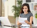 a woman sitting at a desk reading a document