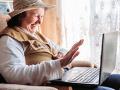 older woman waving "hello" to someone on a video call