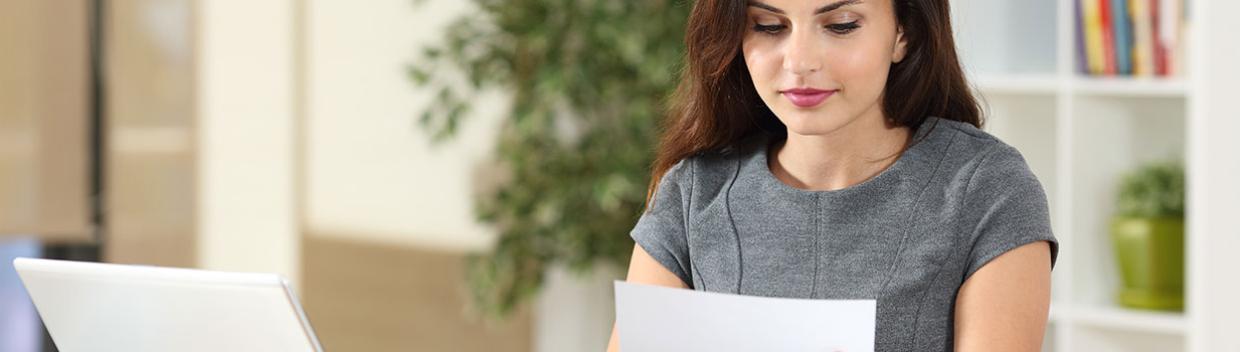 a woman sitting at a desk reading a document