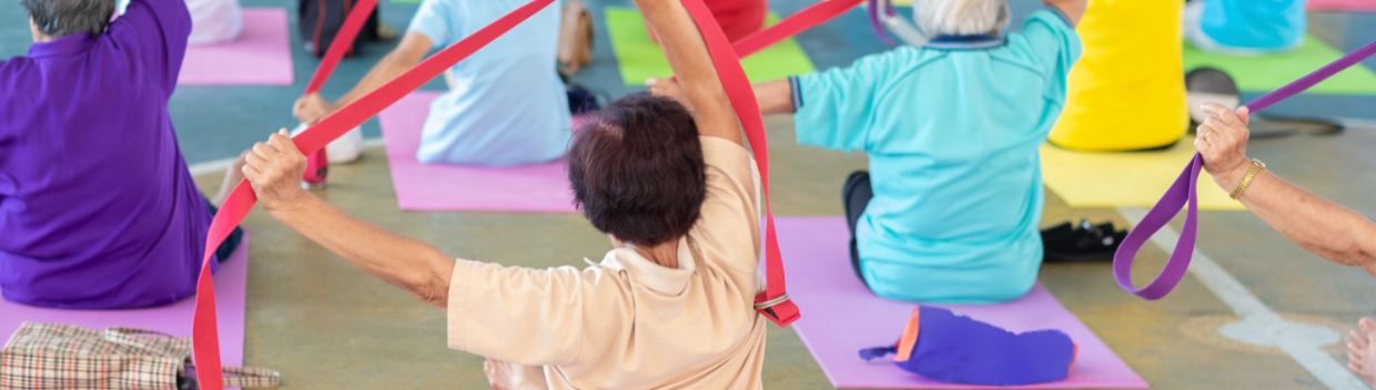 Elders use colorful bands in a yoga class