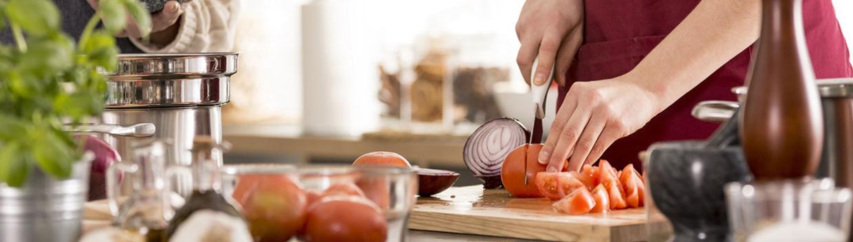 person chops tomatoes on a cutting board