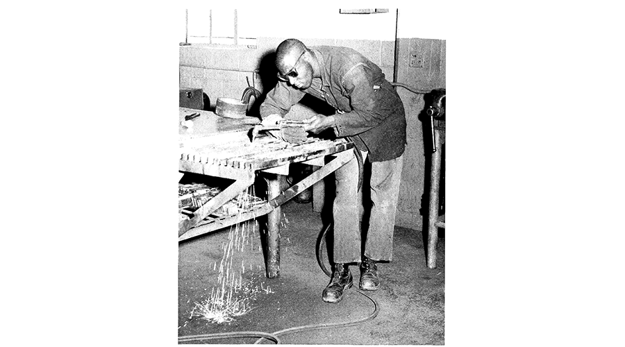 a man leans over a welding machine