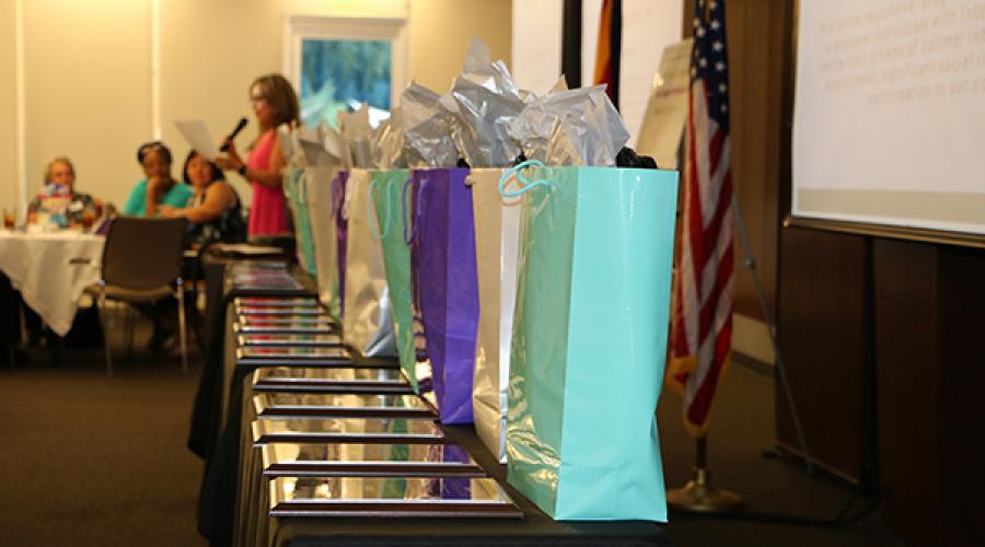 Gift bags and awards line a table 