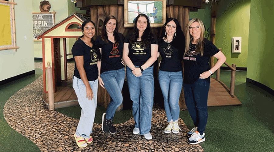 five young women standing in children's playroom