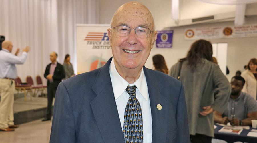 an older man wearing a business suit smiles for the camera