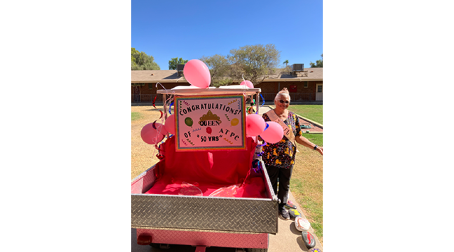 a pink golfcart is decorated with pink balloons and a sign that reads "Congratulations Queen of ATPC - 50 Years"