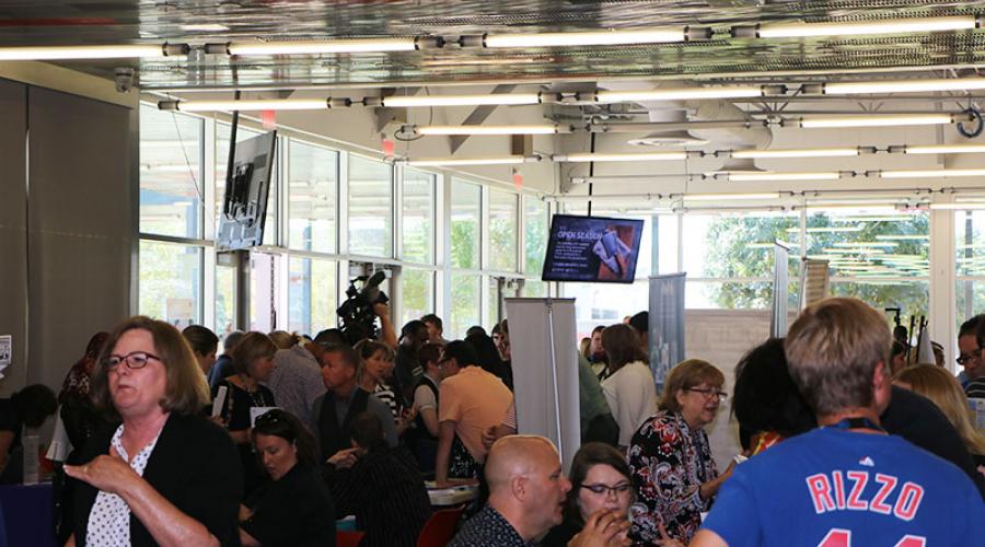  A large crowd of male and female job seekers visiting with employers across from their tables