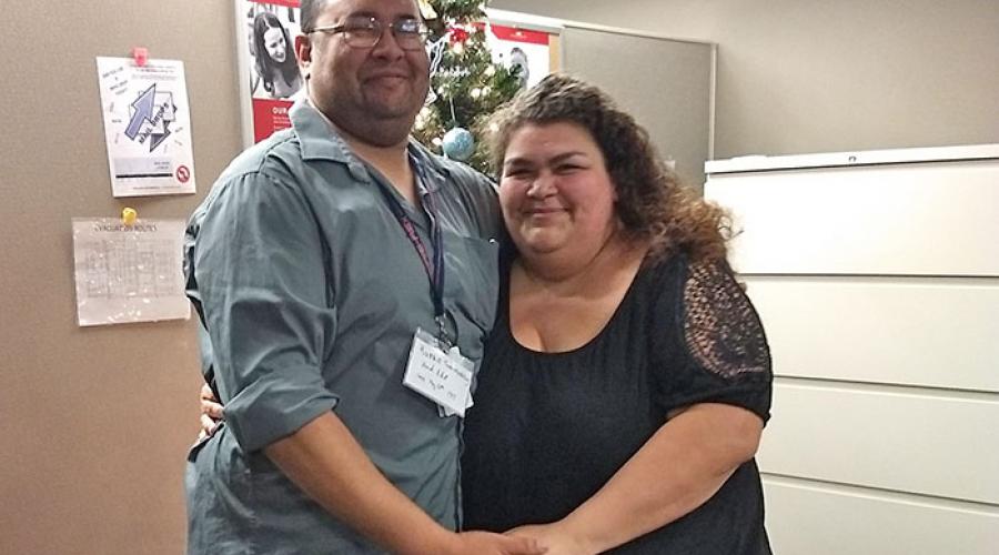 A man and a woman holding hands in an office.