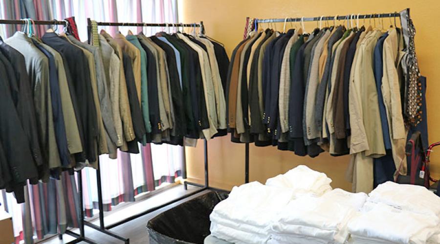 men's jackets fill three clothing racks, a table holds stacks of mens undershirts