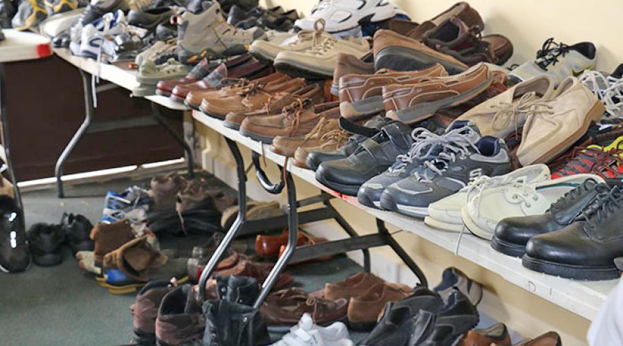 rows of mens shoes sit on top and underneath tables