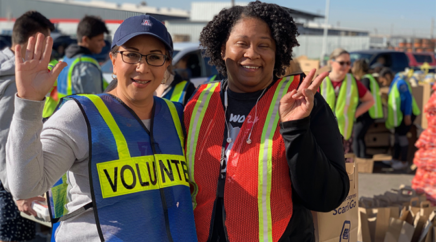 Two DES Volunteers at St. Mary’s Food Bank waving