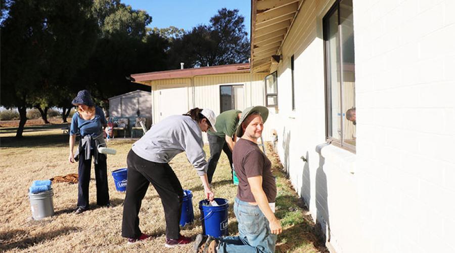 Volunteers paint exterior of home