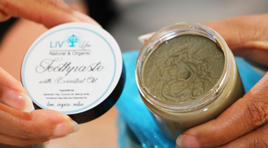 Woman displays open jar of toothpaste