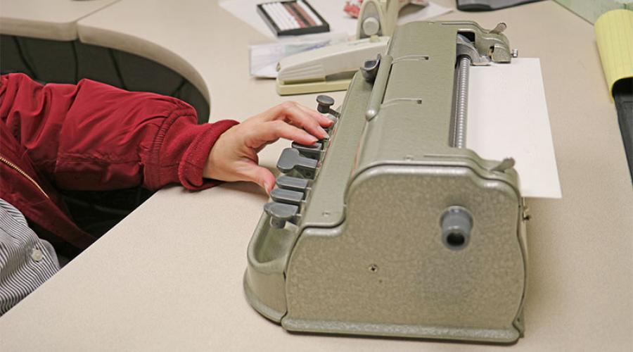 Woman’s hand on Braille Typewriter 