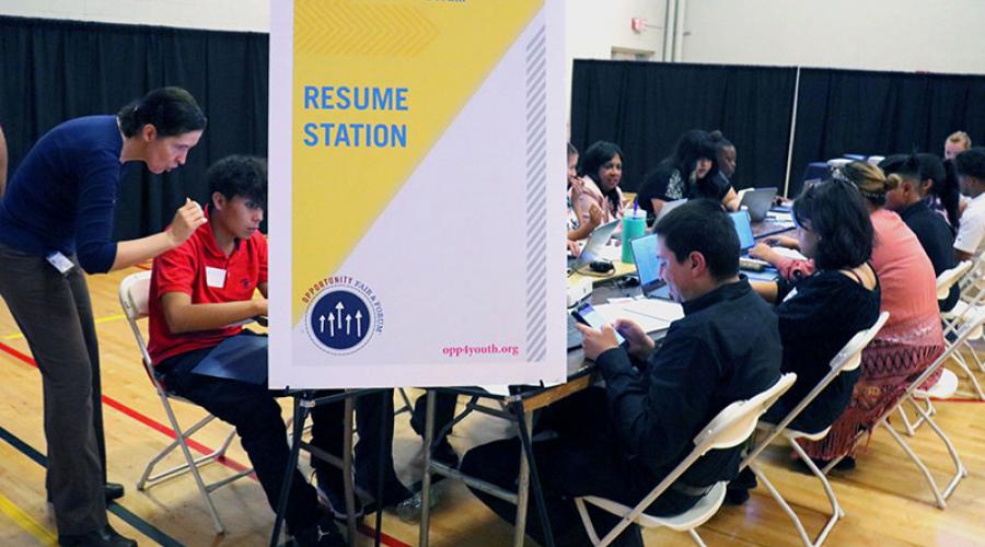 young job seekers work on computers to create resumes
