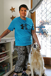 Woman and her dog stand in the foyer of their house