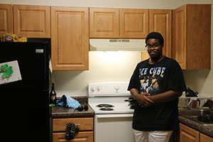 Young man stands in front of his electric stove.